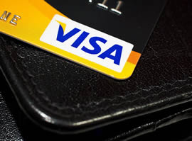 Кредитная карта Visa на фоне черного кошелька