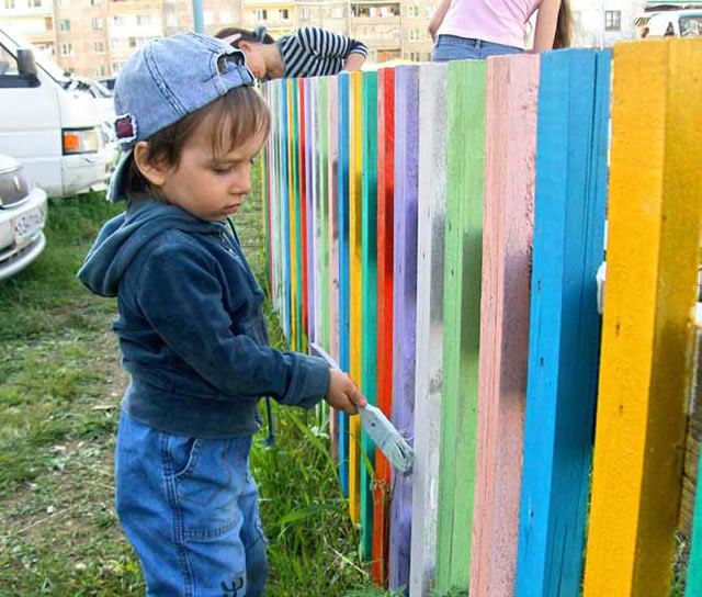 Двухлетний Фёдор Наумкин красит забор на новой игровой площадке